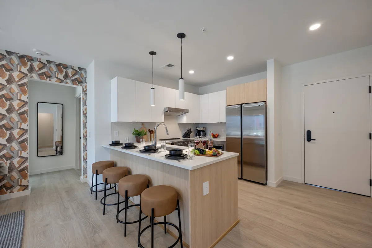A welcoming kitchen scene with a spacious island, modern appliances, and a decorative wall. The setup encourages group cooking, culinary experimentation, and socializing, all within a stylish, contemporary design.